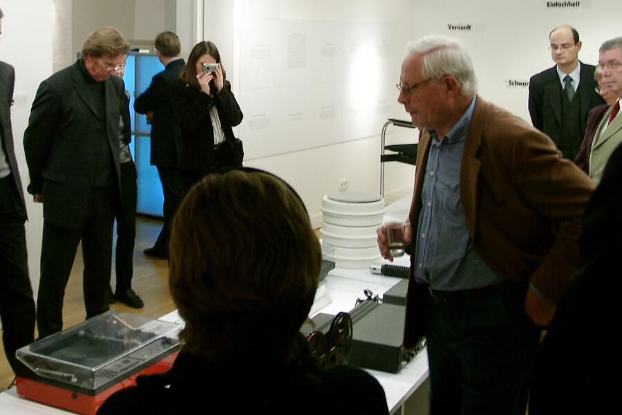 Der Designer Dieter Rams steht mit Besucher:innen 