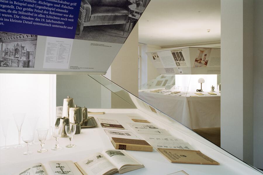 Die Ausstellungselemente sehen aus wie große sechseckige Tische, auf denen Objekte arrangiert wurden.