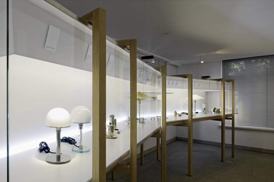 eine lange Vitrine aus Holz und Glas steht diagonal in einem Ausstellungsraum