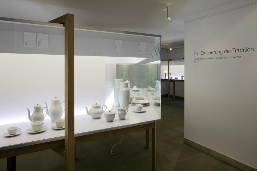 Eine schräg angeschnittene Vitrine mit weißen Porzellan-Entwürfen von Wilhelm Wagenfeld